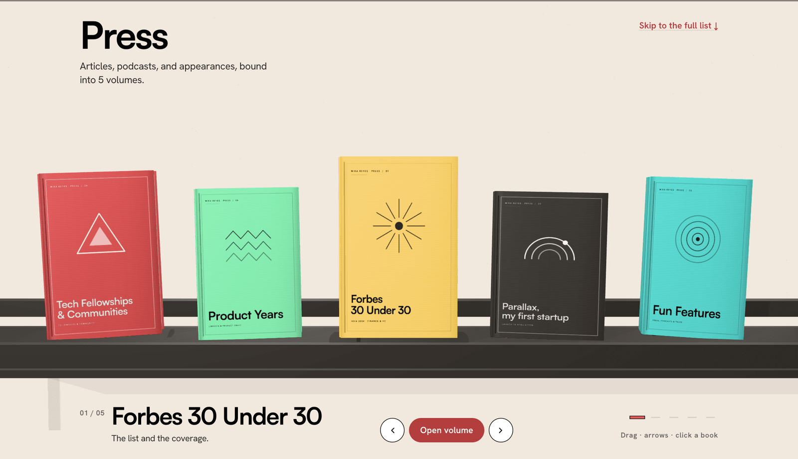 Mika Reyes' press page as a 3D bookshelf of five branded volumes in red, green, yellow, charcoal, and aqua on a charcoal shelf